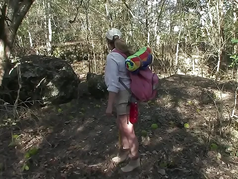 A scary figure awaits a lost hiker in the woods.