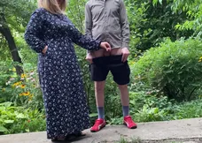 A senior lady helps her stepson pee outside and participates by