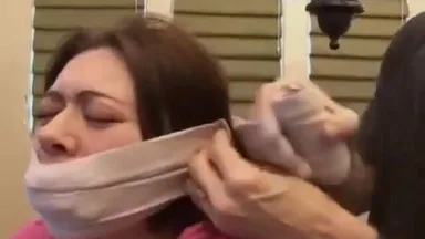 A BDSM scene with a slut tied up and gagged while being